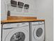 Bright laundry room features front loading washer and dryer and butcher block folding counter at 729 Colby Pl, Durham, NC 27713