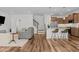 Living area with hardwood floors, gray sofa, staircase and kitchen in background at 729 Colby Pl, Durham, NC 27713