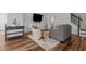 Comfortable living room area with gray sofa, white arm chair, and TV on the wall at 729 Colby Pl, Durham, NC 27713