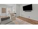 Living room featuring hardwood floors, light gray walls, and mounted flat screen TV at 729 Colby Pl, Durham, NC 27713