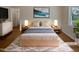 Cozy staged bedroom featuring a neutral color palette, with light hardwood floors and a fluffy rug at 802 Powell Dr, Garner, NC 27529