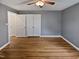 Bedroom featuring hardwood floors, three closets, ceiling fan, and neutral wall paint at 802 Powell Dr, Garner, NC 27529