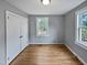 Bright bedroom with closet, hardwood floors, neutral wall paint, and natural light from the window at 802 Powell Dr, Garner, NC 27529
