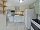 Kitchen featuring white cabinets, appliances, tile floors, and a decorative backsplash at 802 Powell Dr, Garner, NC 27529