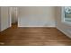 Empty living room with hardwood floors, natural light from the window, and neutral wall paint at 802 Powell Dr, Garner, NC 27529