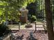 Backyard featuring a paved area with a stone fire pit, surrounded by green foliage and trees at , Raleigh, NC 27613