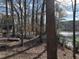 Scenic backyard with a view of the lake, a deck, and a boat, surrounded by trees at , Raleigh, NC 27613