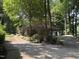 Brick home with a wide driveway and mature landscaping including garden beds and a variety of trees at , Raleigh, NC 27613