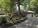 View of the brick home with an attached garage, surrounded by meticulously landscaped gardens and lush greenery at , Raleigh, NC 27613