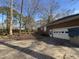Side view of a brick home with a two-car garage and a paved driveway, surrounded by nature at , Raleigh, NC 27613