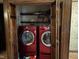 Laundry closet with modern front loading red washer and dryer at , Raleigh, NC 27613