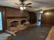 Spacious living room featuring a brick fireplace, wood paneling, and ceiling fans at , Raleigh, NC 27613