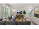 Cozy living room featuring a comfortable gray sectional, stylish decor, large windows, and a view of the staircase at 916 Canis Minor Rd, Wendell, NC 27591