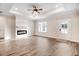 Bright living room with modern fireplace, tray ceiling, ceiling fan, and beautiful laminate flooring at 9230 Bear Run Ln, Middlesex, NC 27557