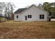 Rear view of home with white siding, black roof, and small patio with grass at 00 Cedar Grove Church Rd Rd, Roxboro, NC 27574