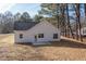 Back exterior showing backyard, white siding, black roof, and small concrete patio at 00 Cedar Grove Church Rd Rd, Roxboro, NC 27574