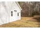 Rear view of home with white siding, black roof, and small back yard with grass at 00 Cedar Grove Church Rd Rd, Roxboro, NC 27574