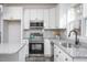 Modern kitchen with stainless appliances, granite countertops, white cabinets, and wood-look floors at 00 Cedar Grove Church Rd Rd, Roxboro, NC 27574