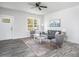 Open living room with gray loveseat, neutral walls, wood-look floors, and a bright window at 00 Cedar Grove Church Rd Rd, Roxboro, NC 27574