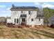 Back exterior view of the home featuring a deck, patio furniture, and a spacious yard at 100 Beech Forest Ct, Cary, NC 27513