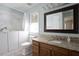 Bathroom with a wood vanity, granite counters, and a bathtub with marble tile at 1402 Princess Anne Rd, Cary, NC 27513