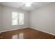 Bedroom with hardwood floors and a large window with natural light at 1402 Princess Anne Rd, Cary, NC 27513