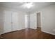 Bedroom with hardwood floors and white doors to a closet and other rooms at 1402 Princess Anne Rd, Cary, NC 27513