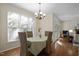 Bright dining area featuring hardwood floors, a view to the outside, and easy access to the living room and kitchen at 1402 Princess Anne Rd, Cary, NC 27513