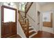 Inviting home foyer featuring hardwood floors, wood stairs, a wood front door and views into other rooms at 1402 Princess Anne Rd, Cary, NC 27513