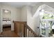 Upstairs hallway with wood railing and a view into a bedroom with a ceiling fan at 1402 Princess Anne Rd, Cary, NC 27513
