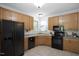 Functional kitchen with wooden cabinets, dark appliances, and tile floors at 1402 Princess Anne Rd, Cary, NC 27513