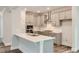 Modern kitchen featuring sleek gray cabinetry, stainless steel appliances, and a quartz-topped island with a sink at 187 E Fountainhead Ln, Garner, NC 27529