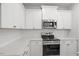White kitchen with stainless steel appliances and subway tile backsplash at 231 Frosted Iris Lane Ln # 174, Garner, NC 27529