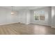 Bright living room with hardwood floors, large window, and modern light fixture at 231 Frosted Iris Lane Ln # 174, Garner, NC 27529