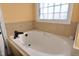 Relaxing bathtub with natural light from a window at 2701 Erinridge Road Rd, Raleigh, NC 27610