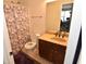 Cozy bathroom with a floral shower curtain and vanity with bronze faucet at 2701 Erinridge Road Rd, Raleigh, NC 27610