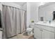 Well-lit bathroom features a shower curtain, toilet, vanity with sink, and large mirror at 2959 Sunflower Rd, Apex, NC 27502