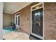 Covered front porch of home with brick exterior and decorative glass front door at 2959 Sunflower Rd, Apex, NC 27502
