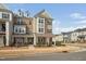 Attractive multi-story townhouse featuring a combination of brick and siding exterior, dormer windows, and landscaping at 2959 Sunflower Rd, Apex, NC 27502