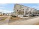 Three-story townhome with a balcony and an attached garage on a sunny day at 2959 Sunflower Rd, Apex, NC 27502