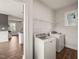 Bright laundry room features modern washer and dryer, storage shelving, and durable wood-look flooring at 304 Ashley Woods Ct, Clayton, NC 27527