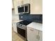 Modern kitchen with stainless steel appliances and black herringbone backsplash detail at 304 White Oak Garden Way # 214, Garner, NC 27529