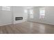 Bright living room featuring modern fireplace, wood floors, and multiple windows at 304 White Oak Garden Way # 214, Garner, NC 27529