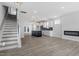 Open-concept living space with wood floors, a modern kitchen, fireplace, and staircase at 304 White Oak Garden Way # 214, Garner, NC 27529