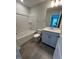 A bathroom with tile floors, tub and shower combo, and vanity with blue painted cabinets at 308 White Oak Garden Way # 215, Garner, NC 27529