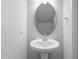 Half bath with pedestal sink, rounded mirror, and modern fixtures at 308 White Oak Garden Way # 215, Garner, NC 27529