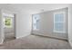 Bright, carpeted bedroom featuring two windows allowing natural light and an open doorway to the next room at 308 White Oak Garden Way # 215, Garner, NC 27529