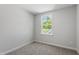 A cozy bedroom with neutral walls and carpet, featuring a window providing a view of lush greenery at 308 White Oak Garden Way # 215, Garner, NC 27529