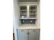 A gray built-in cabinet features glass doors, gray hexagon backsplash, and a light countertop at 308 White Oak Garden Way # 215, Garner, NC 27529