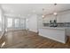 Bright open-concept living space with wood floors flowing into kitchen with center island at 308 White Oak Garden Way # 215, Garner, NC 27529
